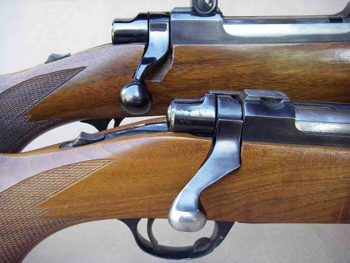 Early M77 rifles featured a nearly S-shaped, flat bolt handle (bottom) while later rifles were fitted with a more traditional swept handle and round knob.